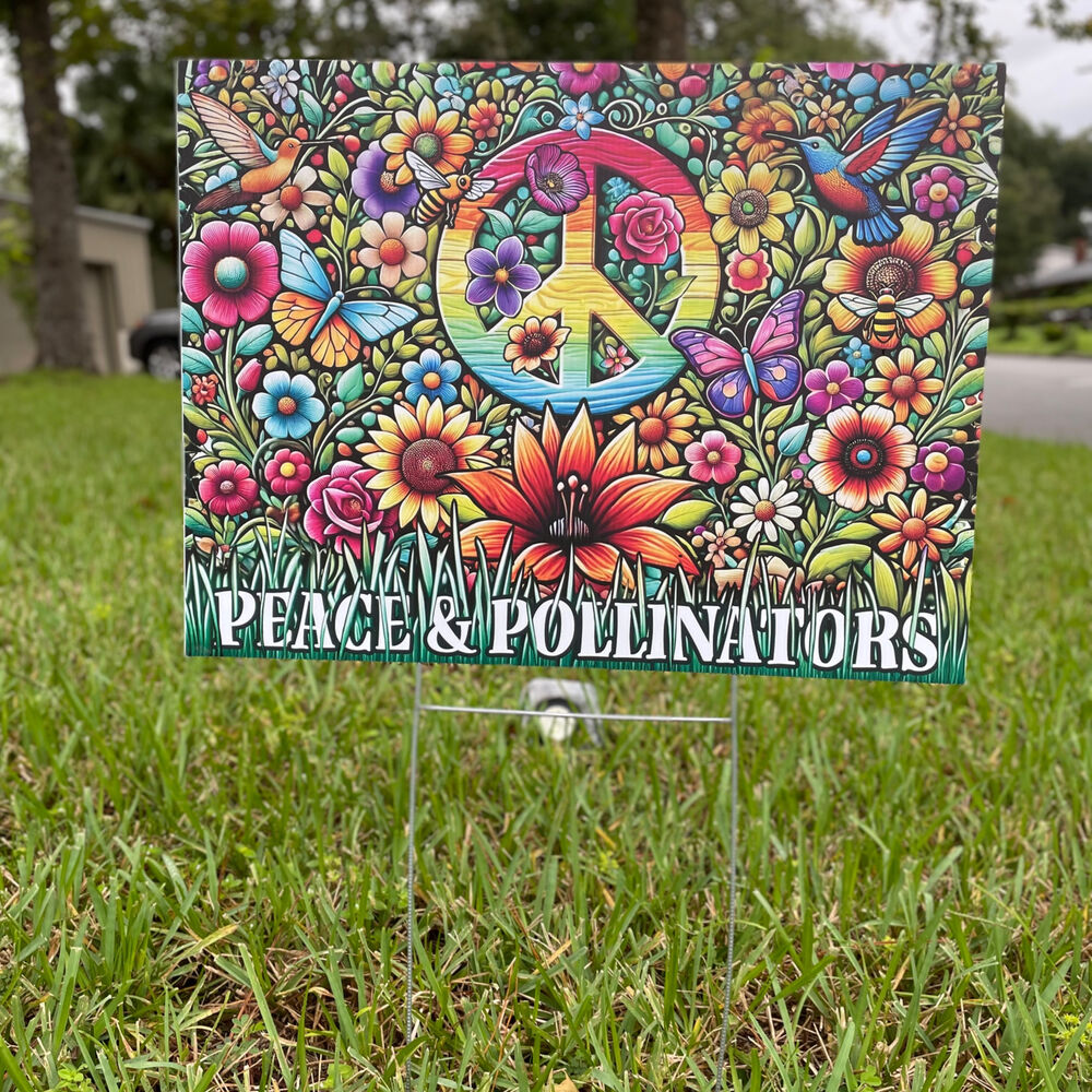 The Peace & Pollinators sign standing in thick grass, seen from the front.